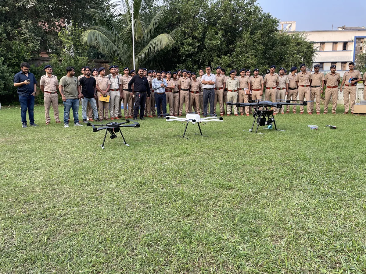 A group gathered behind drones at an outdoor demonstration